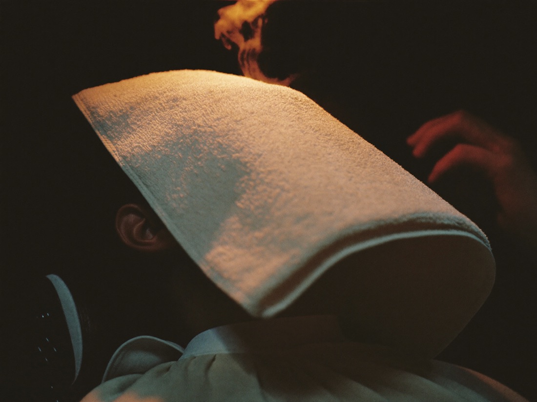 A steaming hot towel lifted from a client's face.